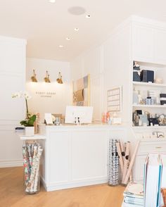 the interior of a store with white walls and shelves filled with books, vases and other items