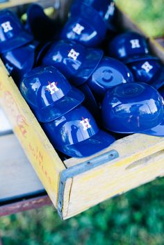 blue ceramic bowls in a wooden box on a table with green grass behind the boxes