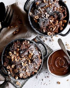 two pans filled with chocolate and nuts on top of a table