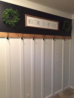 a welcome to my crab sign on the wall next to some hooks and wreaths