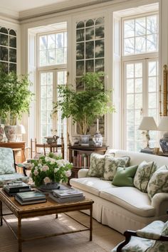 a living room filled with lots of furniture and flowers on top of a coffee table