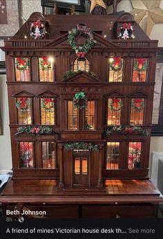 a wooden doll house with christmas decorations on it