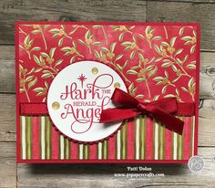 a handmade card with red ribbon and gold foiling on it, featuring the words hark the herald angel