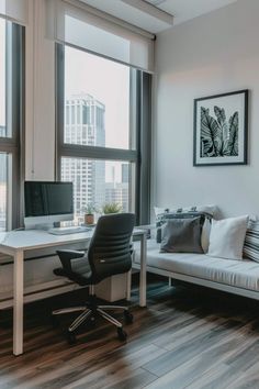 an office with a couch, computer desk and large window overlooking the cityscape