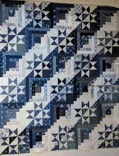 a blue and white quilt hanging on the wall