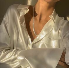 a woman wearing a white shirt and pearl necklace