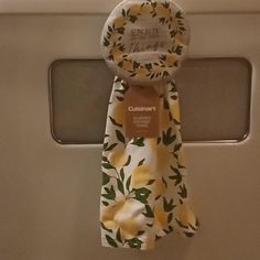 a yellow flowered tie hanging from the side of a door with a name tag on it