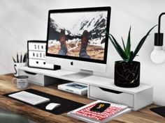 a computer monitor sitting on top of a wooden desk next to a keyboard and mouse