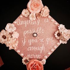 a pink graduation cap with flowers and pearls on it that says, anything is possible if you've got enough nerve