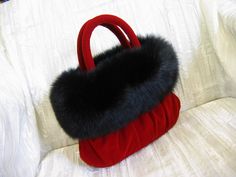 "Another of my luxurious evening bags just perfect to pair with your LBD!    This bag is created from a plush red velvet fabric that is so soft to the touch!  I have decorated the top of the bag with a circle of genuine black fox that is deep and rich feeling also.  Inside the bag is lined with sheet music printed fabric.  It has two inside pockets and closes with a magnetic snap.  Dimensions:  Height: 6.5\" (not including handles) Length: 10.5\" Width: 3\"  Please convo me with any questions an Red Velvet Fabric, Leather Gifts For Her, Carry On Tote, Flower Handbag, Blue Statement Necklace, Luxury Bags Collection, Fur Handbags, Black Fox, Fabulous Furs