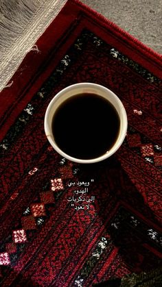 a cup of coffee sitting on top of a rug