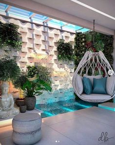 an outdoor living area with hanging chairs and plants on the wall, along with a water feature