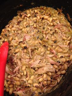 the food is prepared and ready to be cooked in the crock pot with red spatula