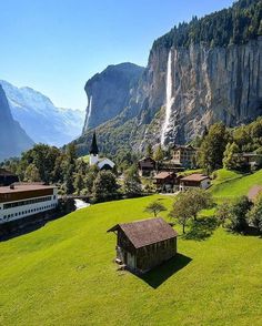 an aerial view of a mountain village with a waterfall in the background