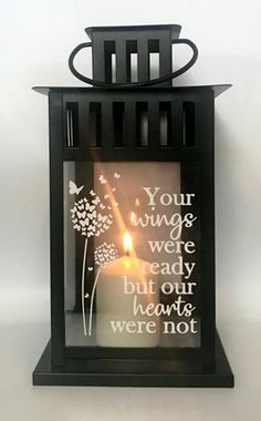 a black lantern with a lit candle in it that says, your wings were ready but our hearts were not