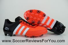 an orange and white soccer shoe with spikes