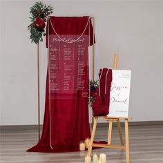 a red chair with a sign and candles on the floor in front of it,