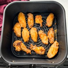 chicken wings are being cooked in an air fryer