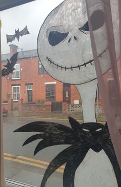 there is a window decorated to look like jack skellingy with bats flying around