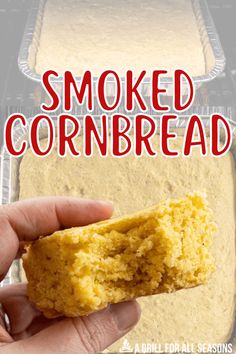 a hand holding a piece of cornbread in front of an oven with the words smoked cornbread on it