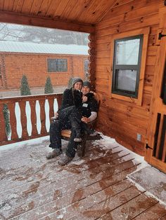 two people sitting on a porch covered in snow