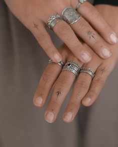 a woman's hand with five rings on it, including an eye and star