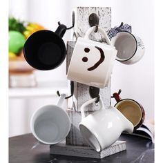 coffee mugs and saucers are hanging on a rack