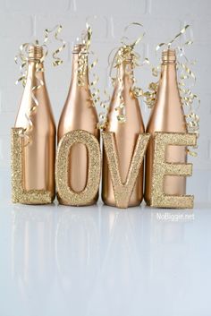 four bottles with the word love spelled out in gold glitter