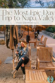 a woman sitting on a wooden chair in front of an umbrella and chairs with text overlay reading the most epic day trip to nap valley from san francisco