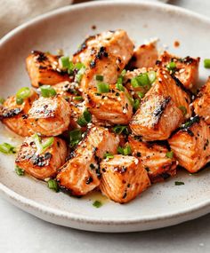 a white plate topped with chicken and green onions