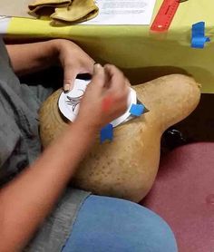 a person cutting paper on top of a squash