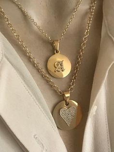 This necklace features two strands. Top strand features a gold plated stainless steel disc with a choice of one CZ old English font(choose at the checkout). Lower chain disc features two styles options: CZ heart and butterfly pendants. 18k gold plated brass chains are sturdy. Total adjustable length(top strand) is 16-18 inches. Lower strand seats lower.  🎁All orders are shipped in a box. Gift messages are attached to the box. Gold-plated Heart Charm Jewelry, Gold Plated Heart Charm Jewelry, Gold Initial Pendant Charm Necklaces For Layering, Gold Initial Pendant Charm Necklace For Layering, Gold Round Charm Necklace With Heart Charm, Gold-tone Round Charm Necklaces, Round Gold Plated Charm Necklaces, Valentine's Day Initial Pendant Charms Jewelry, Gold Adjustable Round Disc Charm Necklaces