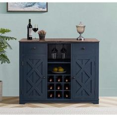 a blue cabinet with wine bottles and glasses on it in front of a wall mounted painting