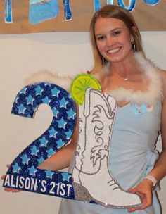 a woman is holding up a sign with the number two on it and wearing boots