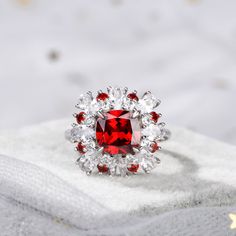 Displaying vivacious feminine flair, this striking fashion ring highlights all that makes her truly exceptional. Crafted in sterling silver, this pretty and unconventional look showcases an cushion cut center stone. Oval cut stones, white round stones and red round stones wrap the centerpiece in a sparkling embrace. Buffed to a brilliant luster, this fabulous conversation piece is sure to be admired often.Carat Weight: 3.7 ctStone Size: 8*8 mmStone Type: Jeulia® StoneNumber of Stones: 1 Stone Color: Garnet RedStone Shape: CushionCarat Weight: 0.62 ctStone Size: 2.3,2 mmStone Type: Jeulia® StoneNumber of Stones: 9 Stone Color: Garnet Red, Diamond WhiteStone Shape: RoundWeight: 6.48 gWidth: 16.4 mmHeight: 8.3 mmThickness: 2.8 mmMaterial: 925 SilverPlating Color: Silver Red Diamond Ring With Brilliant Cushion Cut, Red Cushion Cut Brilliant Diamond Ring, Red Cushion Cut Diamond Ring With Brilliant Cut, Red Cushion Cut Brilliant Ring, Elegant Lab-created Ruby Diamond Ring With Accent Stones, Red Cushion Cut Ring With Accent Stones, Elegant White Ruby Ring With Cubic Zirconia, Elegant Red Crystal Ring With Cubic Zirconia, White Ruby Rings With Brilliant Cut