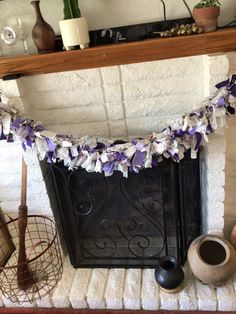 a fireplace decorated with purple and white flowers