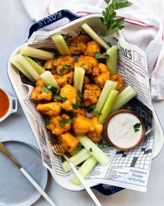 some food that is in a bowl on a table with utensils and napkins