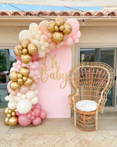 a balloon arch with gold, pink and white balloons