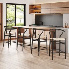 a kitchen with wooden floors and an island table surrounded by bar stools in the center