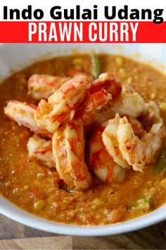 a white bowl filled with shrimp and grits next to a red sign that says indo guai udang praw curry