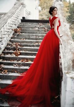 a woman in a red dress standing on some stairs