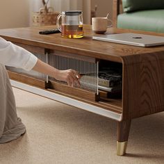 a woman kneeling on the floor in front of a coffee table