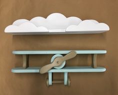 a pair of scissors is hanging on a shelf with clouds above it and below the shelf