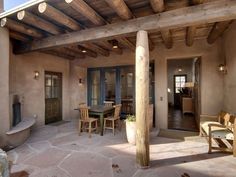 an outdoor living area with chairs, table and fire place