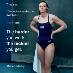 a woman in a blue swimsuit standing next to a blackboard with the quote, they say champions make their own luck it's true