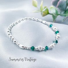 This dainty solid .925 sterling silver bracelet featuring Swarovski Emerald crystals makes the ideal gift for those who celebrate their birthday in May  May is represented in the Swarovski birthstone chart as an Emerald, a deep rich green crystal that symbolizes love, wealth, and happiness  The eclectic mix of sterling silver beads are strung on high quality, strong, professional jewellers' elastic meaning there are no fiddly clasps to deal with, simply roll the bracelet over your hand, and onto your wrist The bracelet comes presented in a beautiful grey faux suede jewellery pouch along with aftercare instructions and a cleaning cloth ☽ SIZE: Available in wrist sizes: Small (17cm), Medium (18cm) or Large (19cm) If you're unsure about sizing please drop me a message and I'll be more than ha Classic Silver Beaded Bracelets As Gift, Classic Beaded Bracelets With Sterling Silver Clasp As Gift, Adjustable Sterling Silver Bracelet With Birthstone For Anniversary, Classic Sterling Silver Beaded Bracelet For Gifts, Classic Silver Beads Bracelet As A Gift, Classic Silver Beads Bracelet Gift, Classic Silver Beaded Bracelet Gift, Classic Sterling Silver Bracelet With Round Beads For Gifts, Adjustable Hypoallergenic Sterling Silver Anniversary Bracelet