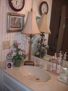 a bathroom sink with a lamp and pictures on the wall