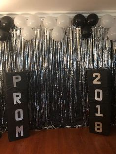 balloons and streamers are hanging from the ceiling in front of a prom party backdrop