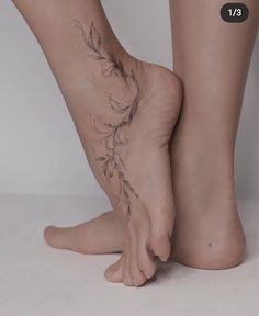 a woman's bare foot with flowers on it and leaves coming out of the toes