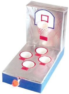 a toy basketball game set up in a cardboard box with cups and plates on it